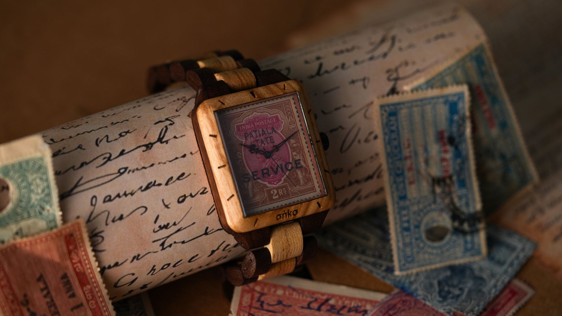 Vintage watch on top of an old letter with stamps and tickets