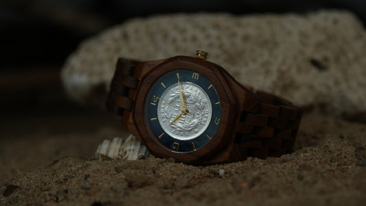 Wooden watch with a detailed face on a sandy background