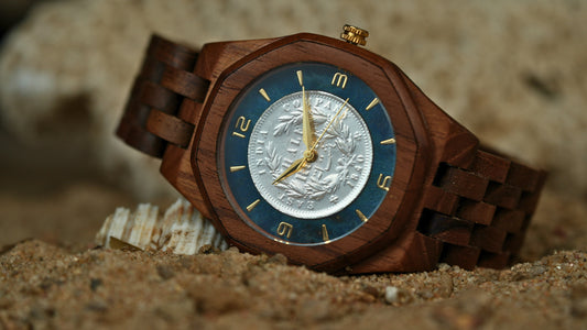 Wooden watch with a detailed face on a sandy background
