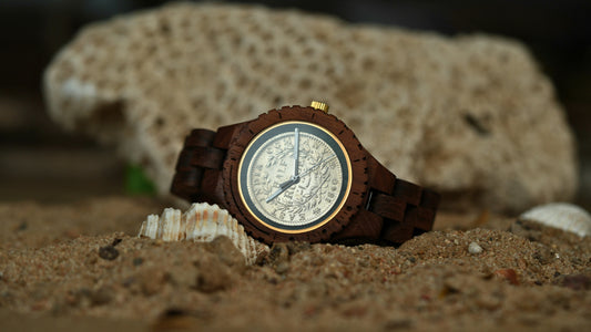 Wooden wristwatch with detailed face on sand and shells