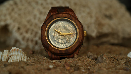Wooden watch with a detailed face on a sandy background